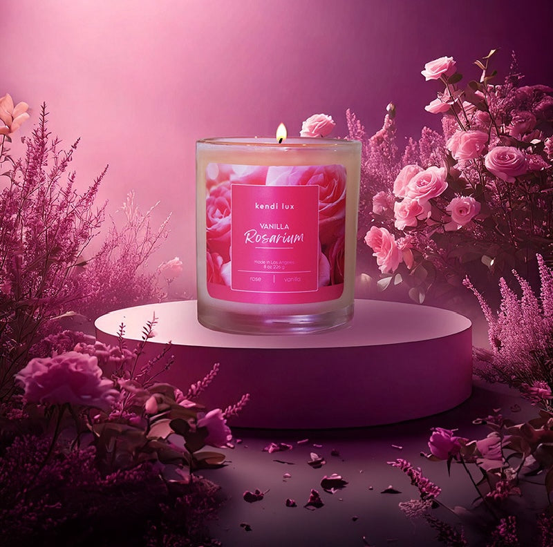 Candle with a pink label on a purple platform surrounded by flowers